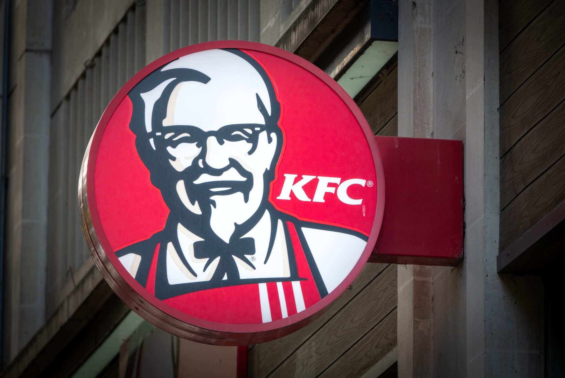 BRISTOL, UNITED KINGDOM - OCTOBER 18: The sun shines on the logo of Colonel Sanders, founder of the Kentucky Fried Chicken fast food restaurant KFC, on October 18, 2023 in Bath, England. American fast food restaurant chain KFC (Kentucky Fried Chicken), specialises in fried chicken. Measure by sales, it is the world's second-largest restaurant chain after McDonald's with branches across the globe including the UK.