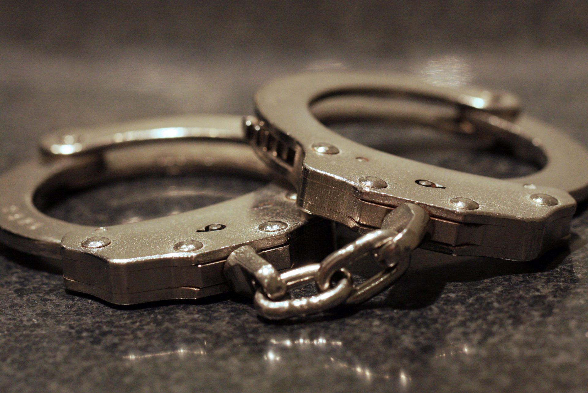 A close up shot of a pair of handcuffs on a table.