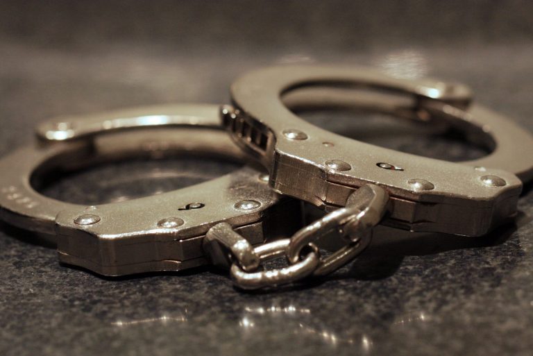 A close up shot of a pair of handcuffs on a table.